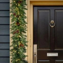 National Tree Company Pre-Lit Artificial Christmas Garland, Green, Garwood Spruce, White Lights, Plug In, Christmas Collection, 9 Feet